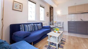 A compact living space with a sofa, dining table, and kitchenette. - Exclusive Apartment Tiffany Ohrid (Ohrid)