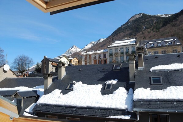 A residential area with snow-covered rooftops and a mountain backdrop. - Joli studio 4P entre télécabine et Commerces (Cauterets)