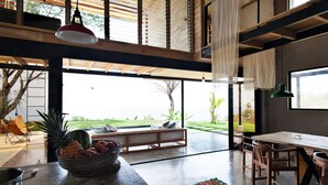 Un amplio salón con un gran ventanal, una mesa de comedor y una zona de estar acogedora.