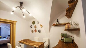 Een moderne keuken met een houten tafel, witte stoelen en een bijzondere hanglamp.