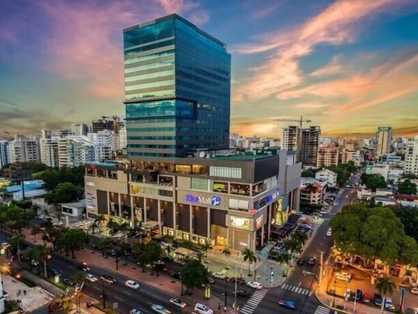 A modern building with a glass facade and a rooftop terrace.
