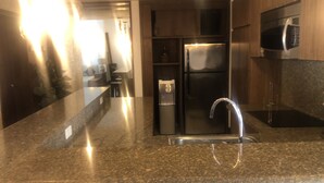 A modern kitchen with granite countertops, stainless steel appliances, and wooden cabinetry. - Aldea Thai Penthouse  2br big private roof top & private pool by oceanfront  (Playa del Carmen)
