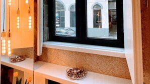 Una ventana con vistas a un edificio de ventanas de arco y un cartel de estacionamiento.