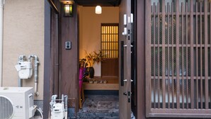 A traditional Japanese entrance with a wooden door and a sliding glass window.