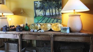 A wooden table with a painting of trees, two lamps, and various decorative items. - Beautiful  countryhouse in rural surroundings with pool and pool house.   (Grignan (Drome Provencale))