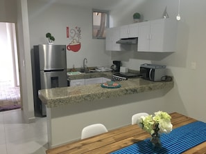 A modern kitchen with white cabinets, a stainless steel refrigerator, a coffee maker, and a toaster. - Progreso, Yucatan  beach condo Playa Chaca ground floor (Progreso)