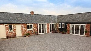 A two-story building with a gravel driveway and a brick facade. - Secluded, family and pet friendly - close to Peppa Pig World and the New Forest (ROMSEY)