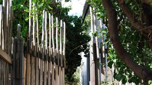 Ein hölzernes Tor führt in einen Garten mit einem Kiesweg.