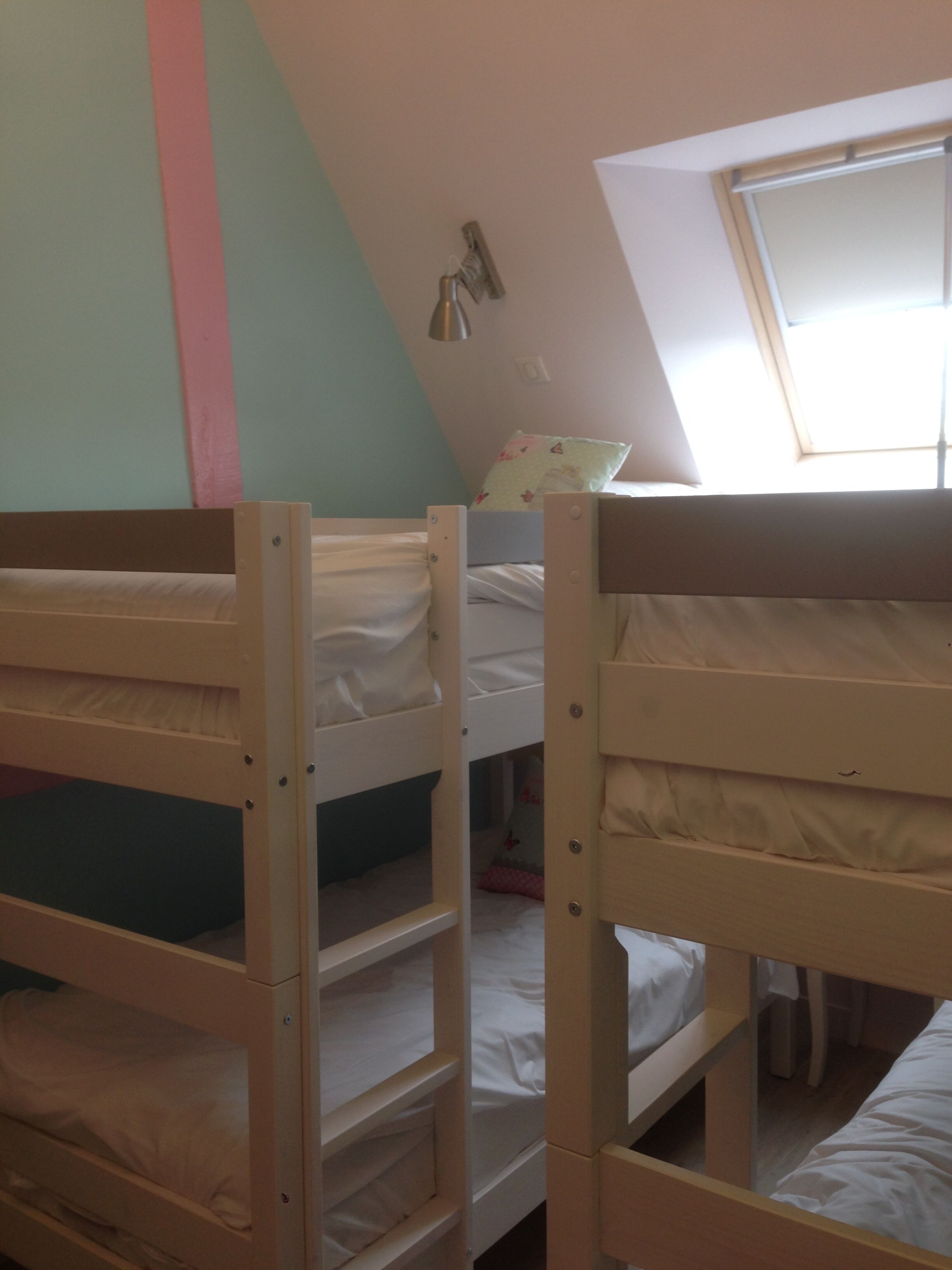 Bunk beds in a room with a sloped ceiling and a window.