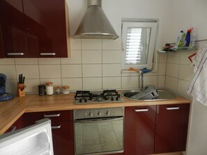 Een koelkast, een oven, een kookplaat, een koffiezetapparaat/waterkoker