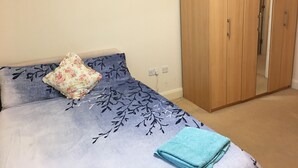 A bedroom with a bed, a wardrobe, and a mirror. - Comfy and cozy apartment with two bedrooms  (Birmingham)