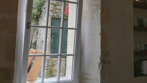 Ein Zimmer mit großem Fenster, einer Pendelleuchte und Blick ins Freie.