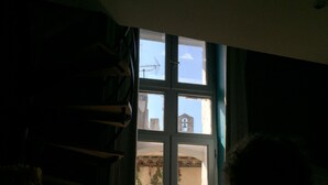 Una habitación con ventana, radiador y cortina.