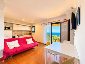 A compact room with a bed, a dining table, and a kitchen area. - Beautiful studio in Calella de Palafrugell with sea views! (Palafrugell)