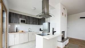 A modern kitchen with a central island, stainless steel appliances, and a glass backsplash.