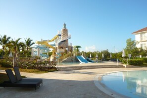 Een waterpark met een grote glijbaan, een zwembad en ligbedden.