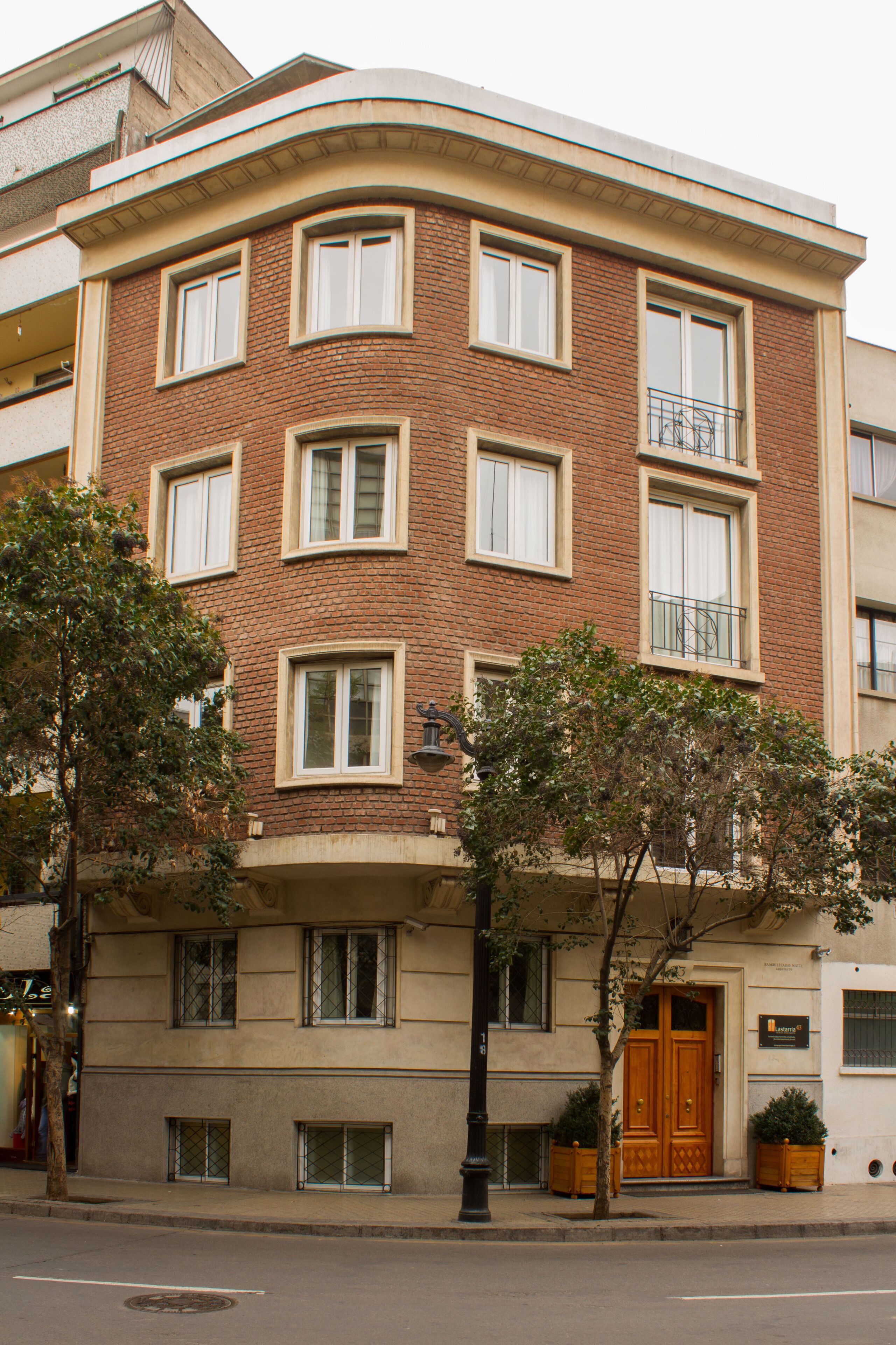 A multi-story building with a corner entrance, large windows, and a balcony.