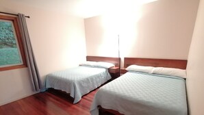 A room with two beds, wooden flooring, and a window with curtains. - Perfect house for friends and family in Monteverde (Monteverde)