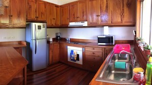 A kitchen with wooden cabinets, a refrigerator, a microwave, and a sink. - Perfect house for friends and family in Monteverde (Monteverde)