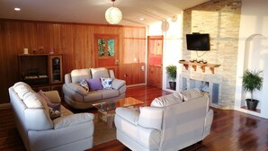 A living room with a fireplace, wooden walls, and a television mounted on the wall. - Perfect house for friends and family in Monteverde (Monteverde)