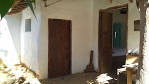 A rustic room with a wooden door, a small staircase, and a wooden chair. - Great view and clean air (Barichara)