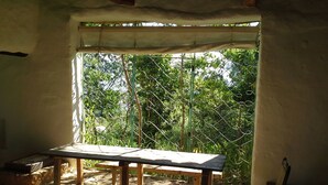 A room with a wooden table under a window with a metal fence outside. - Great view and clean air (Barichara)