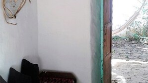A room with a rustic wooden ceiling, a patterned sofa, a wall-mounted decorative item, and a doorway leading outside. - Great view and clean air (Barichara)