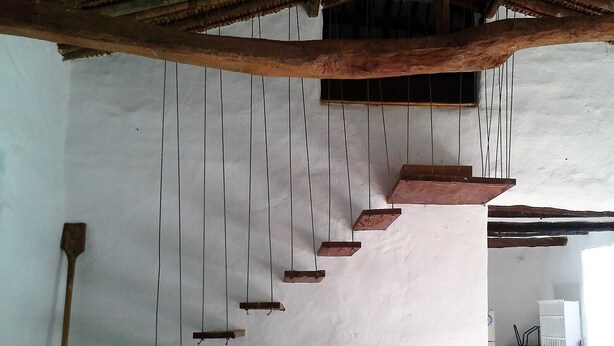 A staircase with wooden steps descending into a room. - Great view and clean air (Barichara)