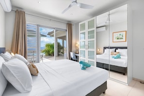 Une chambre d’hôtel avec un grand lit, un bureau, une chaise et un balcon avec vue.