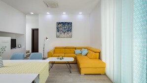 Un salon moderne avec un canapé jaune, une table basse blanche et une nappe à motifs.