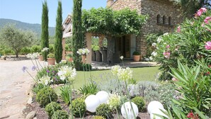A stone house with a garden featuring various plants and flowers.