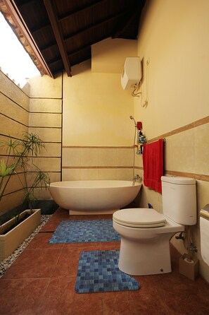 Bathroom features a bathtub, toilet, and wall-mounted showerhead.