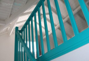 A turquoise staircase railing in a building with white walls and a high ceiling. - le "Madras Blue" Duplex, Baie Nettlé, piscine-vue (Marigot)