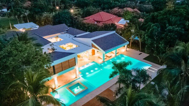 A modern house with a swimming pool, surrounded by lush greenery. - Luxury Villa: 6 Rooms, 12 Pax, Infinity Pool, Hot Tub, Staff, Close to the Beach (La Romana)