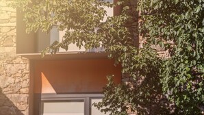 Una piscina amb una escala metàl·lica, un flotador de salvament i una paret de pedra.