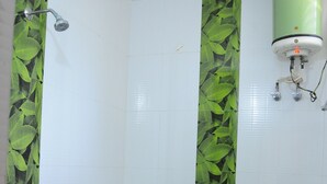 A bathroom with a toilet, a shower, and a green water heater.