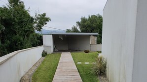 A modern house with a wooden deck leading to a covered patio area. - Beautiful house ideal for relaxation (Bela Monção)