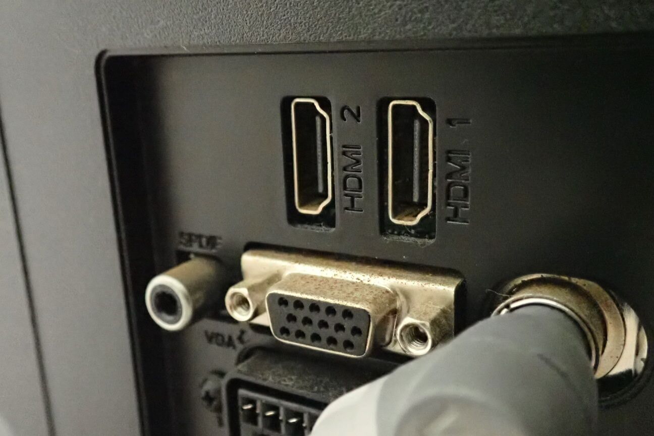 Eine Nahaufnahme vom Rückspiegel eines Autos und einem Teil des Armaturenbretts, einschließlich eines HDMI-Anschlusses und eines VGA-Anschlusses.