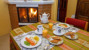 Una mesa de comedor preparada con platos de comida, tazas y una tetera.