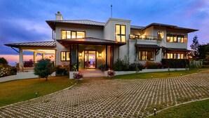 Una casa moderna de dos pisos con un césped cuidado y un camino de entrada pavimentado.