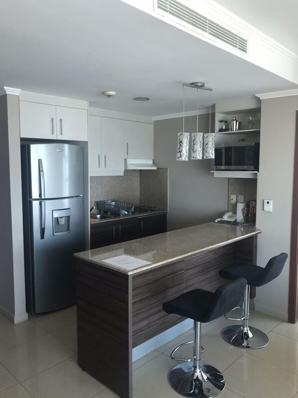 Fridge, microwave, coffee/tea maker, cookware/dishes/utensils