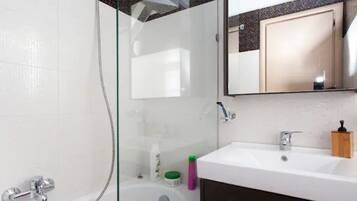 Bathtub, hair dryer, towels, shampoo