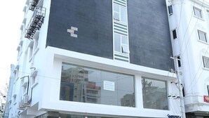 A modern building with a large window and a sign indicating a business or service on the ground floor. - Lariviera falcon nest in Madhapur  (Hyderabad)