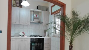 A compact kitchen with light wood cabinets, a built-in oven, and a gas stove.