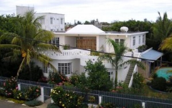 A modern two-story house with a white exterior, a covered porch, and a swimming pool.