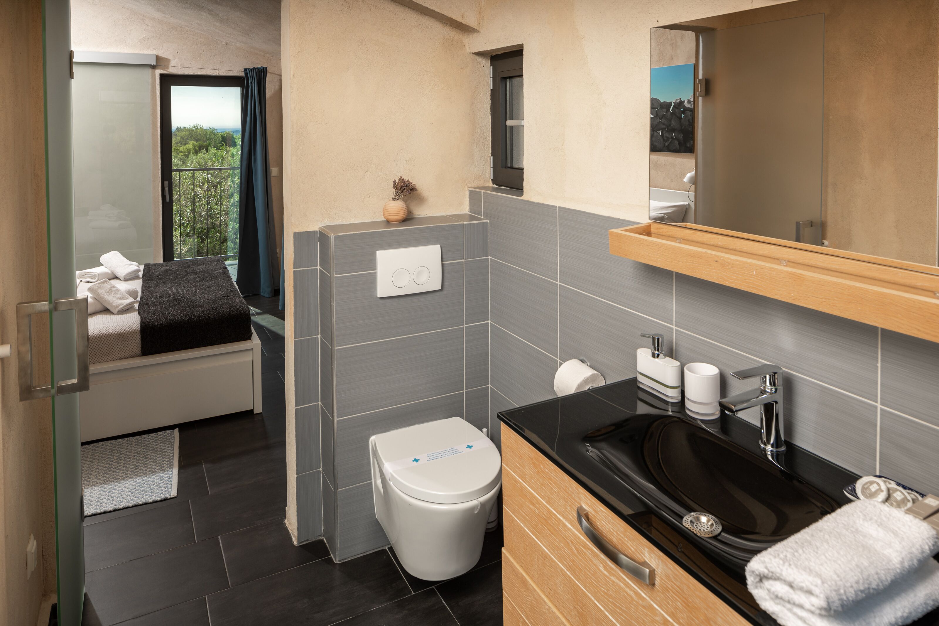 Een moderne badkamer met toilet, wastafel en grote spiegel.