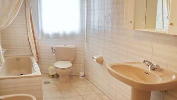 Een douche, handdoeken, zeep, toiletpapier