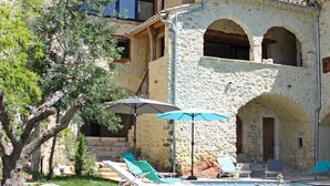 Ein Steingebäude mit Pool, Außenbereich und einer Treppe, die zu einem Balkon führt.