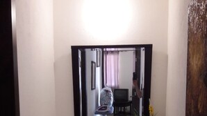 Een badkamer met een grote spiegel, een wastafel en een kastje.