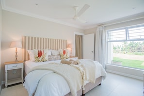 Main bedroom overlooking the large lawn with sea views. Luxurious king EL bed